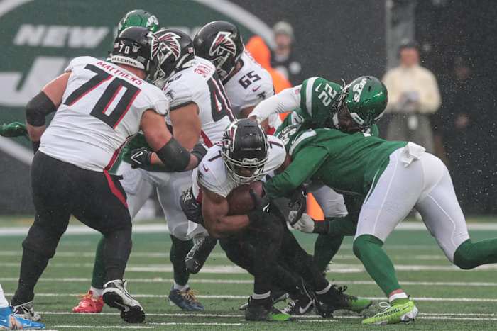 Dec 3, 2023; East Rutherford, New Jersey, USA; Atlanta Falcons running back Bijan Robinson (7) is tackled by New York Jets linebacker Jermaine Johnson (11) and safety Tony Adams (22) during the first quarter at MetLife Stadium.